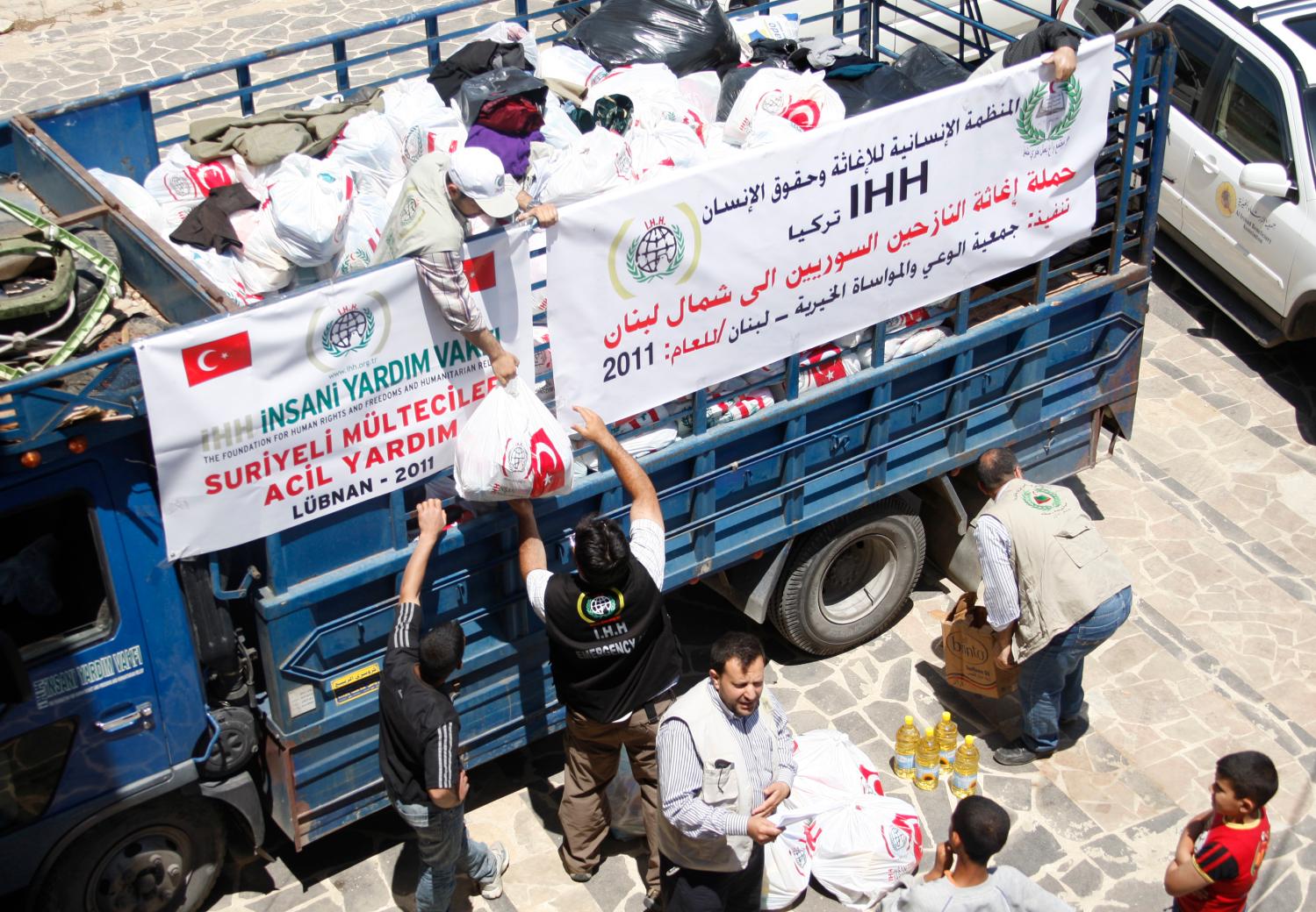 Workers prepare to deliver food and humanitarian aid from a Turkish relief agency to Syrian refugees at the northern Lebanese village of Wadi Khaled near the Lebanese-Syrian border, May 21, 2011. Syrians who fled for their lives from a security crackdown in the border town of Tel Kelakh say violence has hardened attitudes towards Syria's President Bashar al-Assad and unrest will not end until he steps down. REUTERS/Omar Ibrahim (LEBANON - Tags: POLITICS SOCIETY CIVIL UNREST) - RTR2MP74