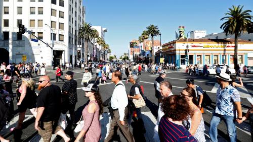 People cross the intersection of Hollywood Blvd and Highland Avenue in Hollywood