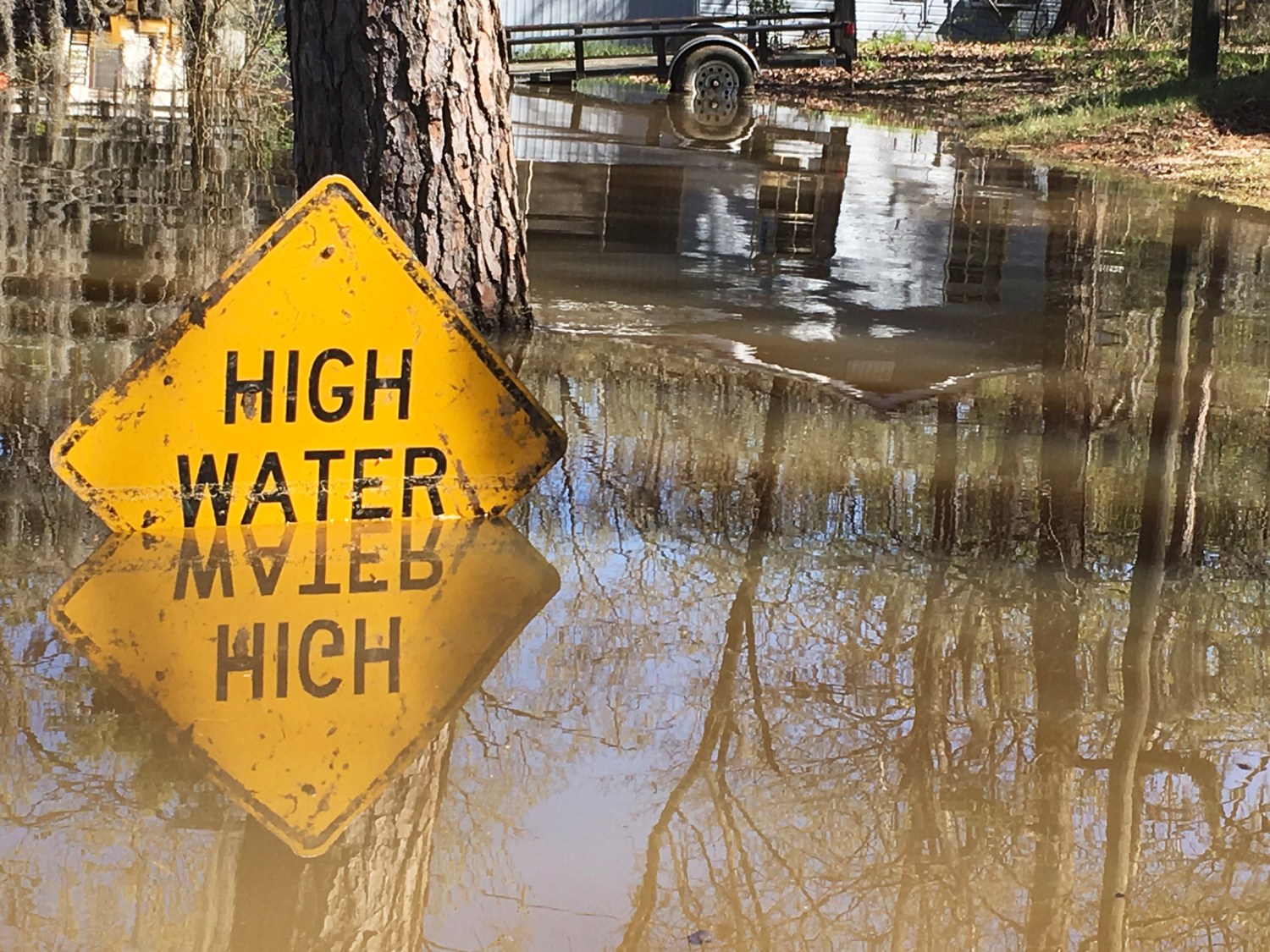 REUTERS/Therese Apel - A high water sign is submerged near Lake Bistineau in Webster Parish, Louisiana March 14, 2016. The death toll from storms in Southern U.S. states rose to five as storm-weary residents of Louisiana and Mississippi watched for more flooding on Monday from drenching rains that inundated homes, washed out roads and prompted thousands of rescues.