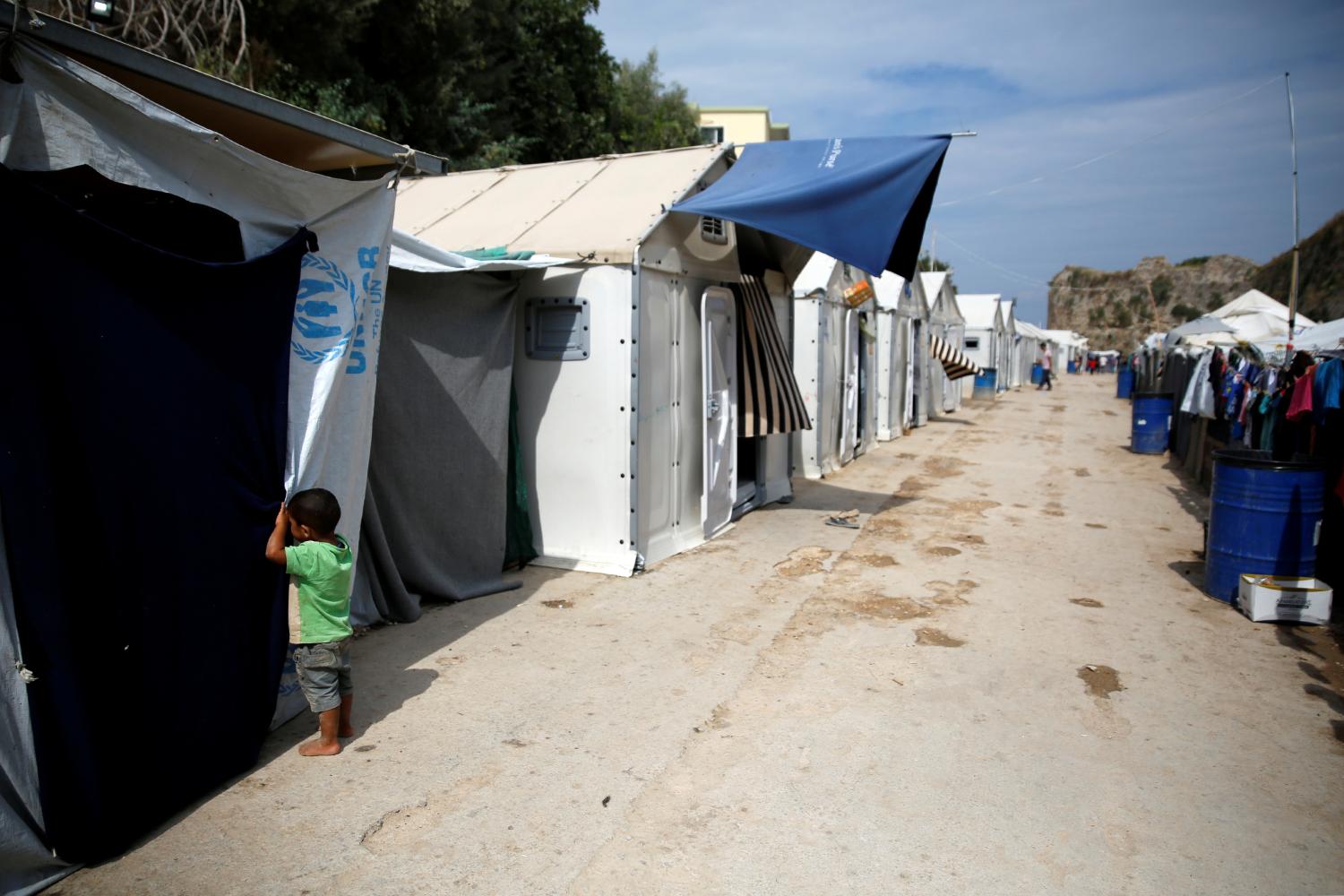 A boy looks inside a tent at the Souda municipality-run camp for refugees and migrants on the island of Chios, Greece, September 6, 2016. REUTERS/Alkis Konstantinidis - RTX2OEK0