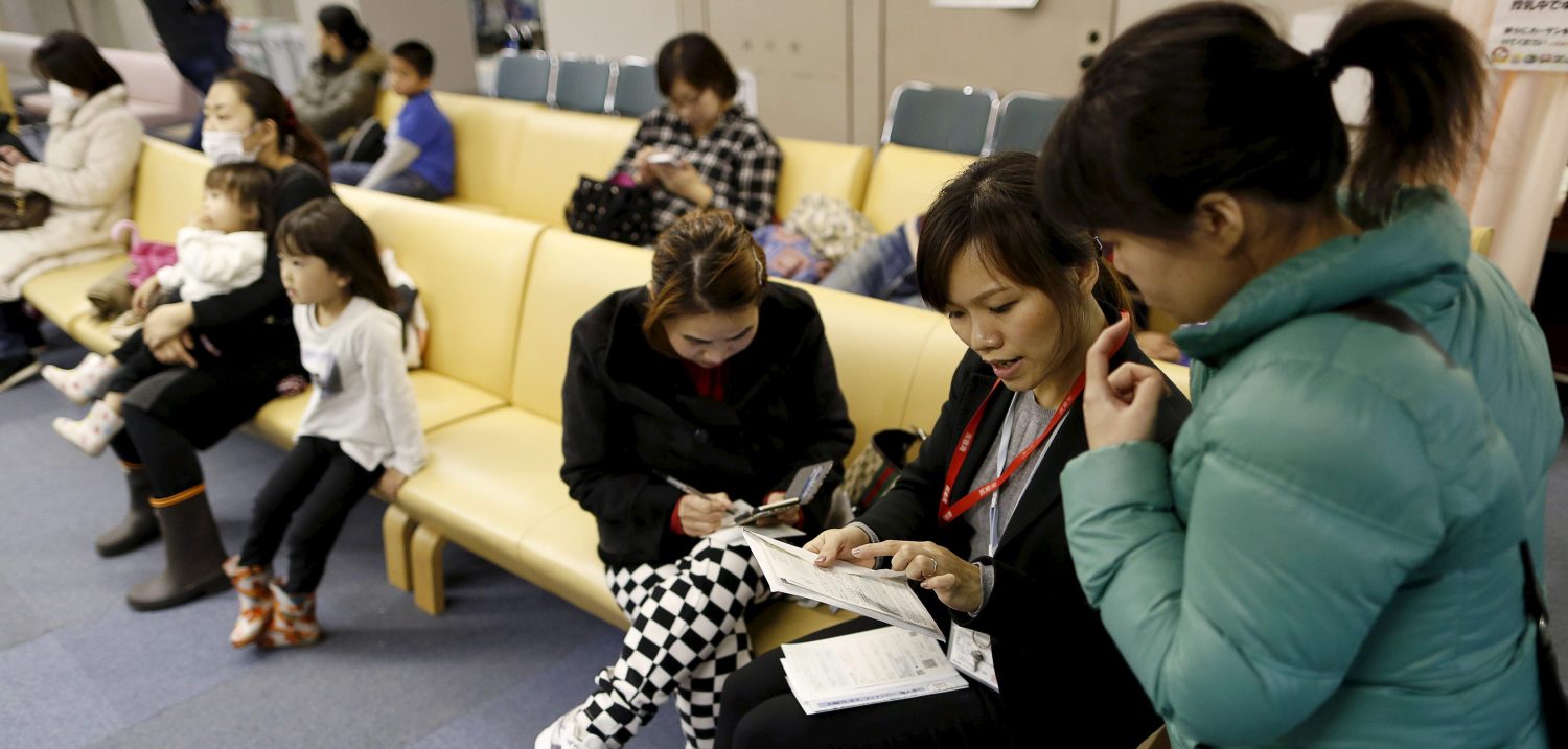Dang Nguyen Thuc Vien (2nd R), a 32-year-old daughter of refugees from south Vietnam, helps a local Vietnamese resident in Japan as an interpreter at a hospital in Kanagawa prefecture, south of Tokyo, Japan, November 25, 2015. Picture taken November 25, 2015. REUTERS/Yuya Shino - RTX1WAPK