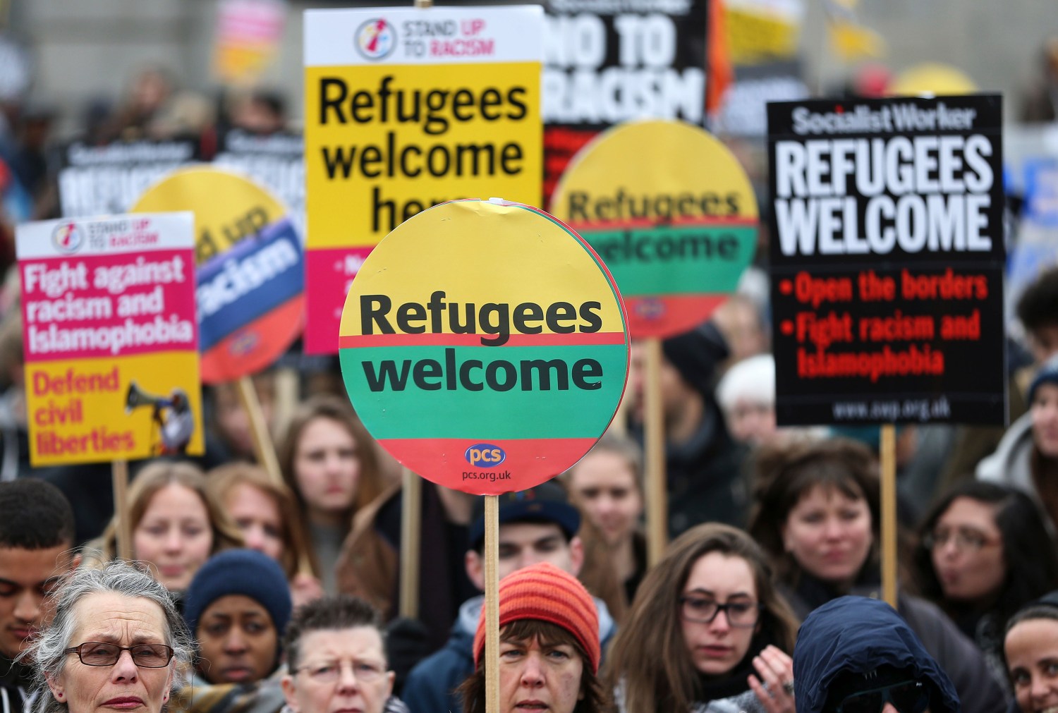 Demonstrators hold placards during a refugees welcome march in London, Britain March 19, 2016. REUTERS/Neil Hall - RTSB7L0