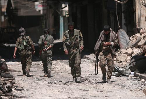 Syria Democratic Forces (SDF) fighters walk on the rubble of damaged shops and buildings in the city of Manbij, in Aleppo Governorate, Syria, August 10, 2016. REUTERS/Rodi Said - RTSMDAF