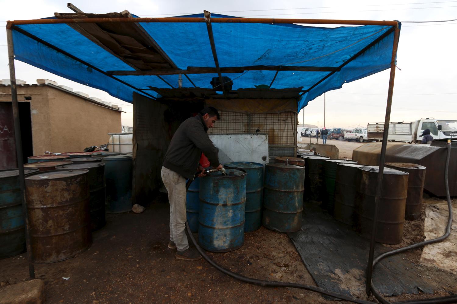 A man fills drums with oil for sale at the Syrian town of Ras al-Ain, close to the Turkish border, January 23, 2016. REUTERS/Rodi Said