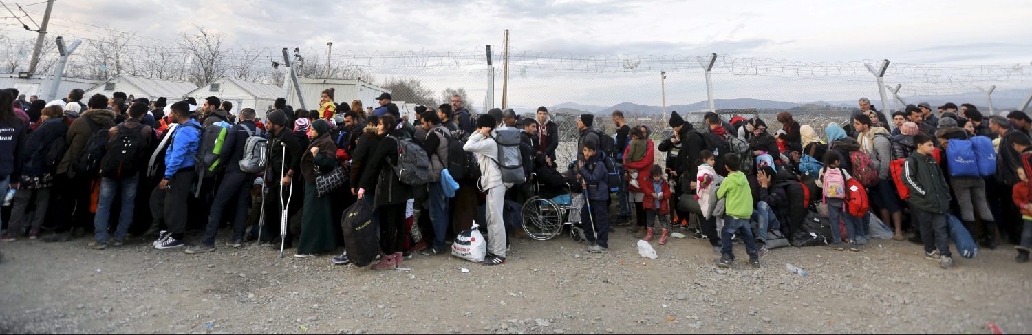Syrian and Iraqi refugees line up next to a fence at the Greek-Macedonian border February 27, 2016 as the border crossing is briefly reopened near the Greek village of Idomeni. REUTERS/Yannis Behrakis - RTS8AFP
