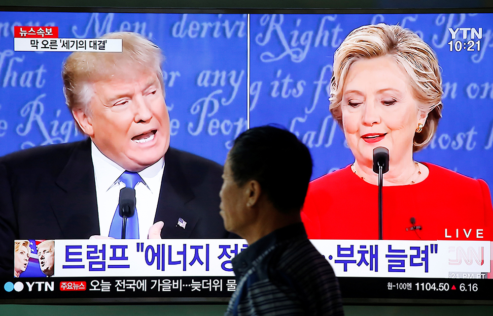 A man in Seoul walks past a TV broadcast of the first presidential debate between U.S. Democratic presidential candidate Hillary Clinton and Republican presidential nominee Donald Trump