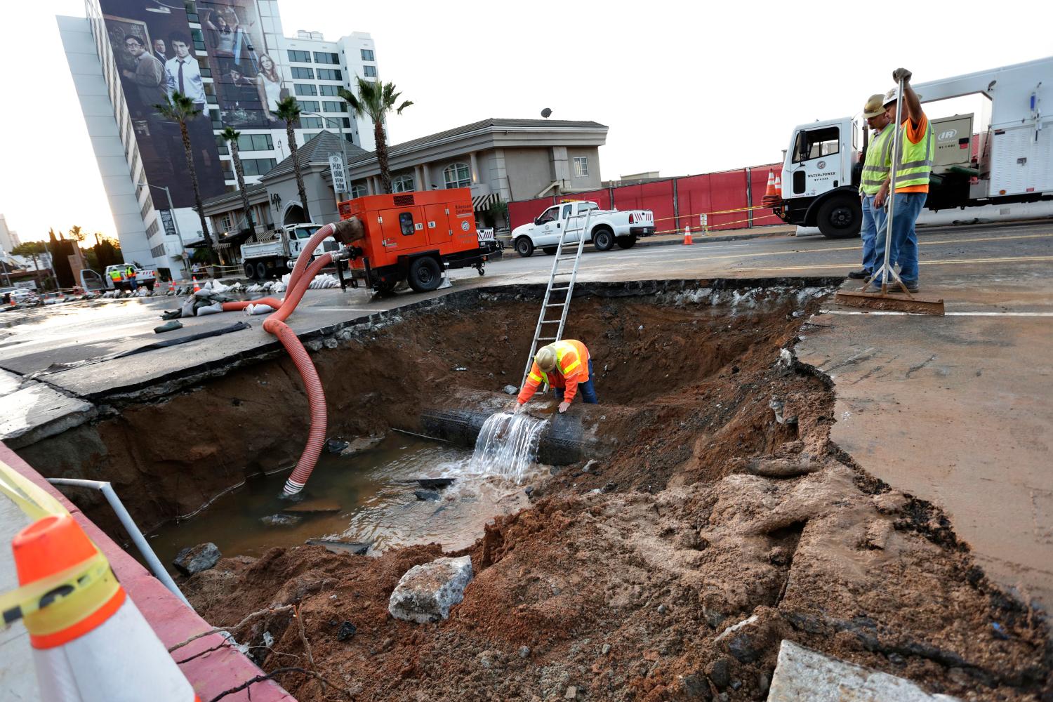 REUTERS/Jonathan Alcorn- A Los Angeles Department of Water and Power worker looks at the source of a major water main break on Sunset Boulevard in West Hollywood, Los Angeles, California September 27, 2014. A large water pipe burst under West Hollywood on Friday, flooding the famed Sunset Strip and forcing authorities to shut down the thoroughfare to vehicle traffic during the evening rush hour.