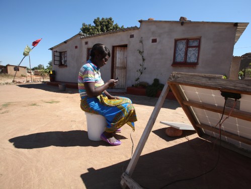 A women checks a message on her mobile phone in Epworth, east of the capital Harare, Zimbabwe