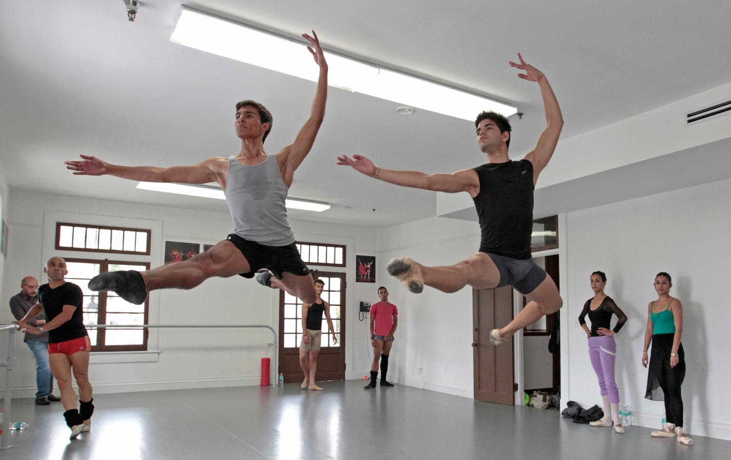 Dancers Josue Justiz (L) and Edward Gonzalez Morgado from the Cuban National Ballet, who defected last month, leap during their audition at the Miami Hispanic Ballet in Miami, Florida April 4, 2013. The Cuban national ballet, known for its adherence to a classical style of ballet and for producing many world-class dancers, regularly makes international tours. Over the years, many of its dancers have defected and joined other companies abroad. Others have been allowed to leave Cuba freely, including Carlos Acosta with the Royal Ballet in London and Jose Manuel Carreno, who retired in 2011 as a much revered principal dancer at the American Ballet Theatre in New York. REUTERS/Joe Skipper (UNITED STATES - Tags: POLITICS SOCIETY IMMIGRATION) - RTXY8T3