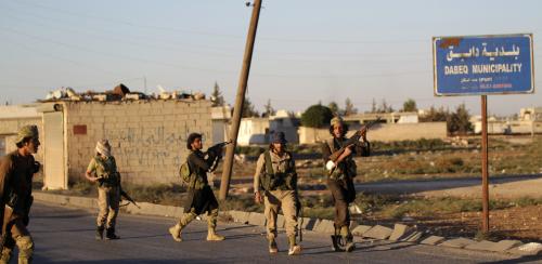 Rebel fighters walk with their weapons in Dabiq town, northern Aleppo countryside, Syria October 16, 2016. REUTERS/Khalil Ashawi - RTX2P3YF