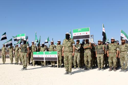 Fighters from Jaish al-Izzah, part of the Free Syrian Army, stand in attention during a military display as part of a graduation ceremony at a camp in the Hama province, Syria July 29, 2016. REUTERS/Ammar Abdullah - RTSK90N