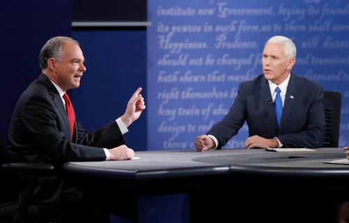 Tim Kaine and Mike Pence speak simultaneously while seated during the vice presidential debate on October 4, 2016.