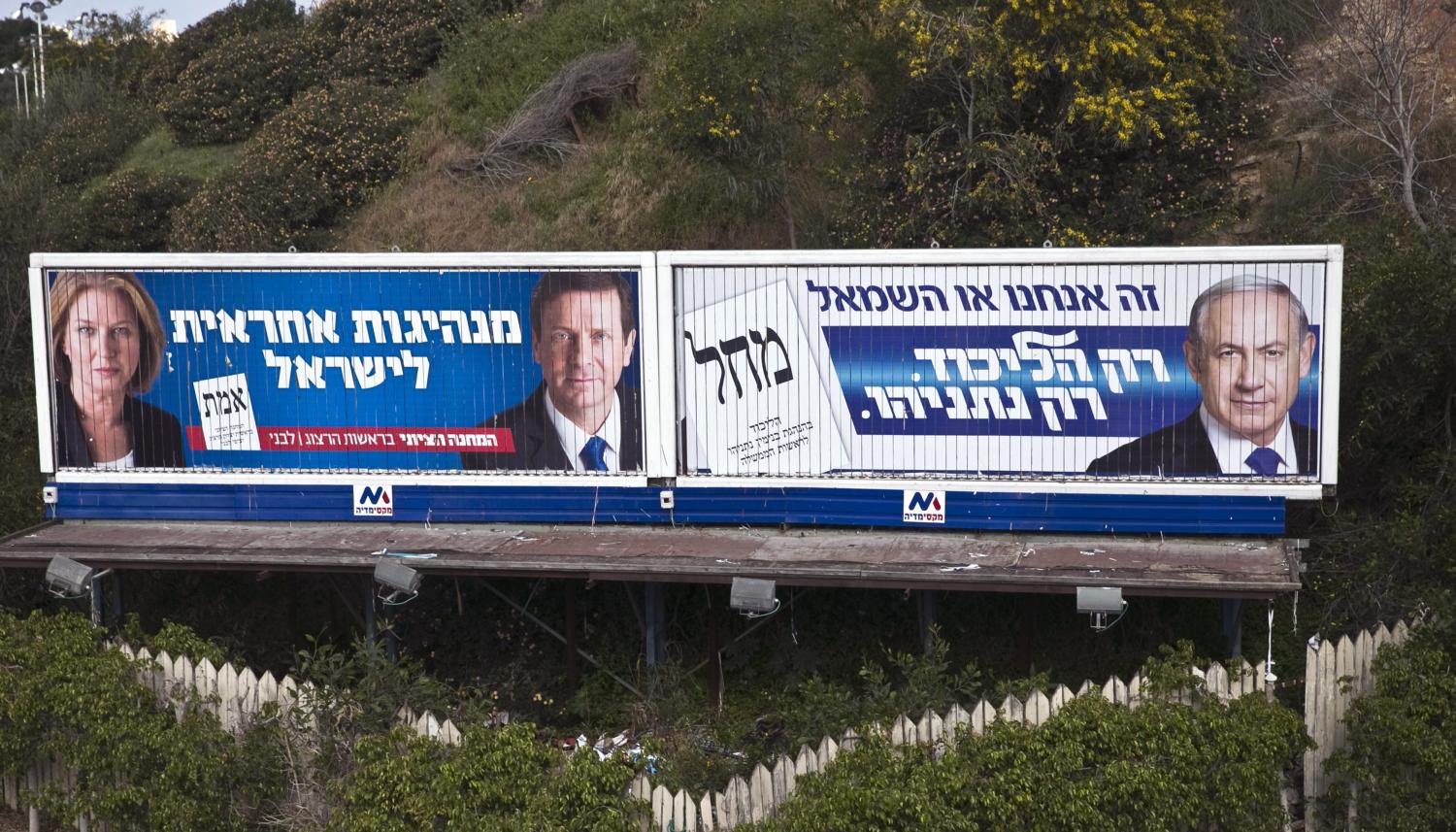 Israel's Prime Minister Benjamin Netanyahu, Isaac Herzog and Tzipi Livni are depicted on Likud (R) and Zionist Union (L) campaign billboards in Tel Aviv March 15, 2015. Israel's centre-left opposition is poised for an upset victory in next week's parliamentary election, with the last opinion polls before Tuesday's vote giving it a solid lead over Netanyahu's party. REUTERS/Baz Ratner (ISRAEL - Tags: POLITICS ELECTIONS) - RTR4TFG2