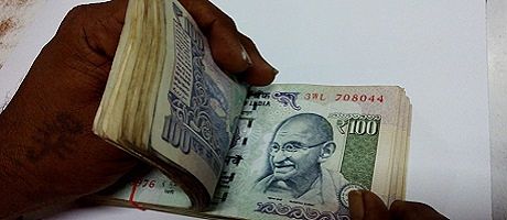 A person flips through a large stack of money.