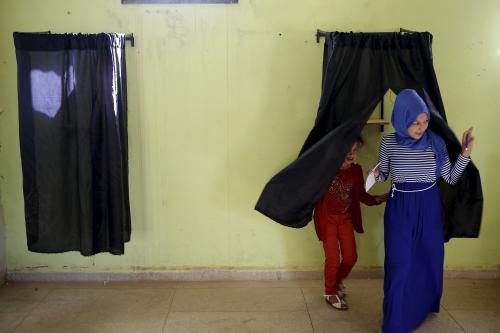 A woman (L) leaves a booth before casting her ballot at a polling station in the town of Tifelt, east of Rabat, Morocco September 4, 2015. Morocco's ruling Islamist party on Friday faced a major test of its dominance as polls opened for local elections for which most opposition parties have campaigned on anti-corruption platforms and against privileges for the elite. REUTERS/Youssef Boudlal TPX IMAGES OF THE DAY - RTX1R65C