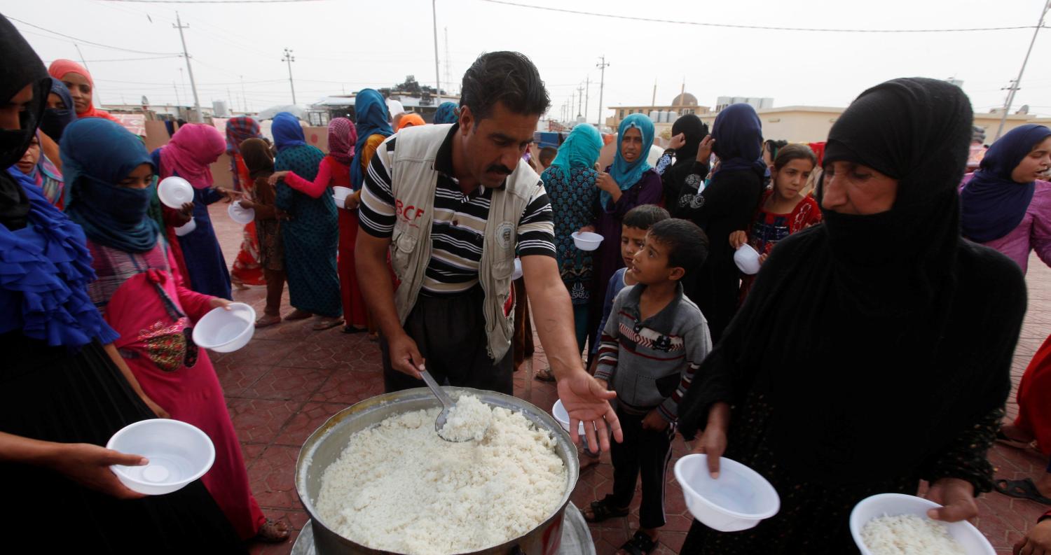 Women who recently fled the Islamic State's stronghold on the outskirts of Mosul queue to receive food at the school at Debaga camp, on the outskirts of Erbil, Iraq October 28, 2016. REUTERS/Alaa Al-Marjani - RTX2QV62