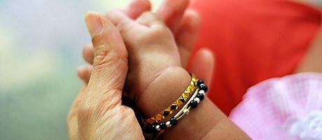 A picture of a mother holding her child's hands.