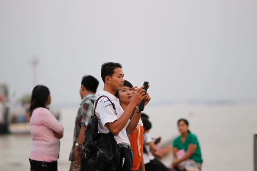 A couple looks at their mobile phone after taking a self portrait