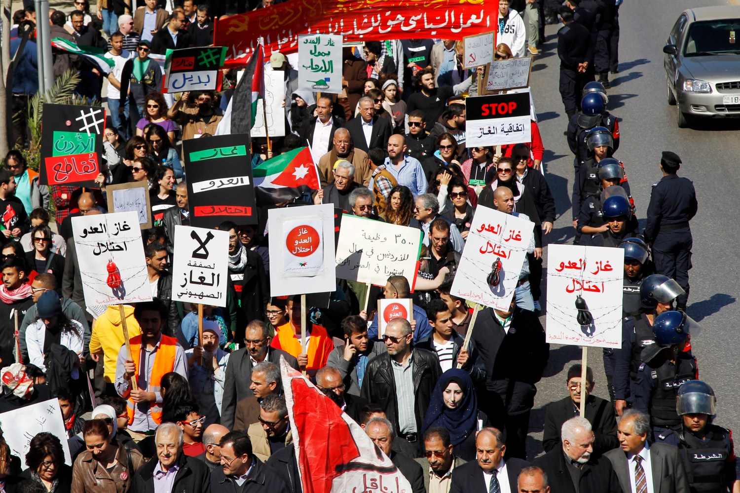 Jordanian protesters take part in a march against a government agreement to import natural gas from Israel, in Amman March 6, 2015. The placards read "The enemy's gas is occupation" (R) and "No to the Zionist gas deal" (2nd L). REUTERS/Majd Jaber (JORDAN - Tags: POLITICS CIVIL UNREST BUSINESS ENERGY) - RTR4SBEK