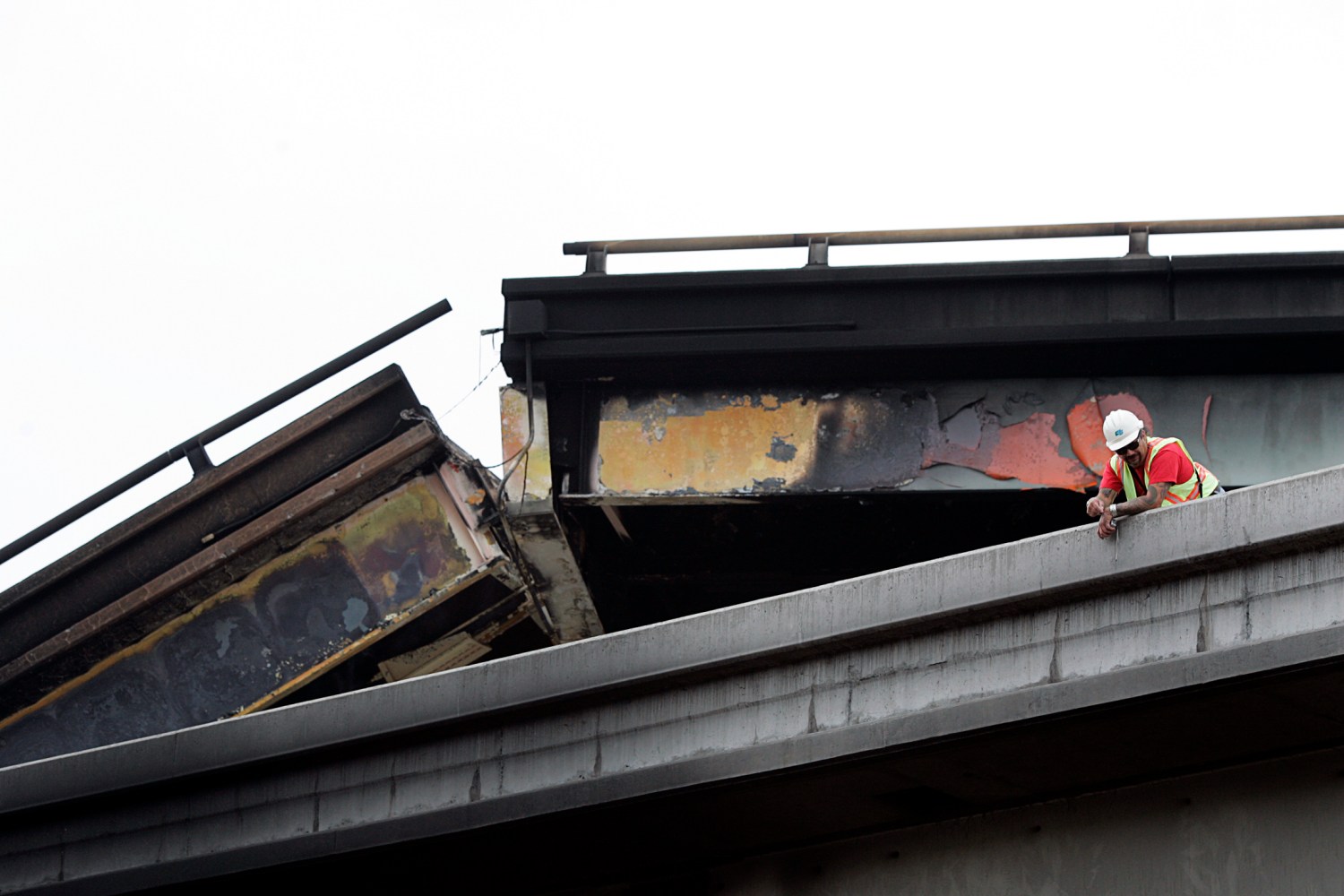 A city employee inspects a collapsed highway in Oakland, California