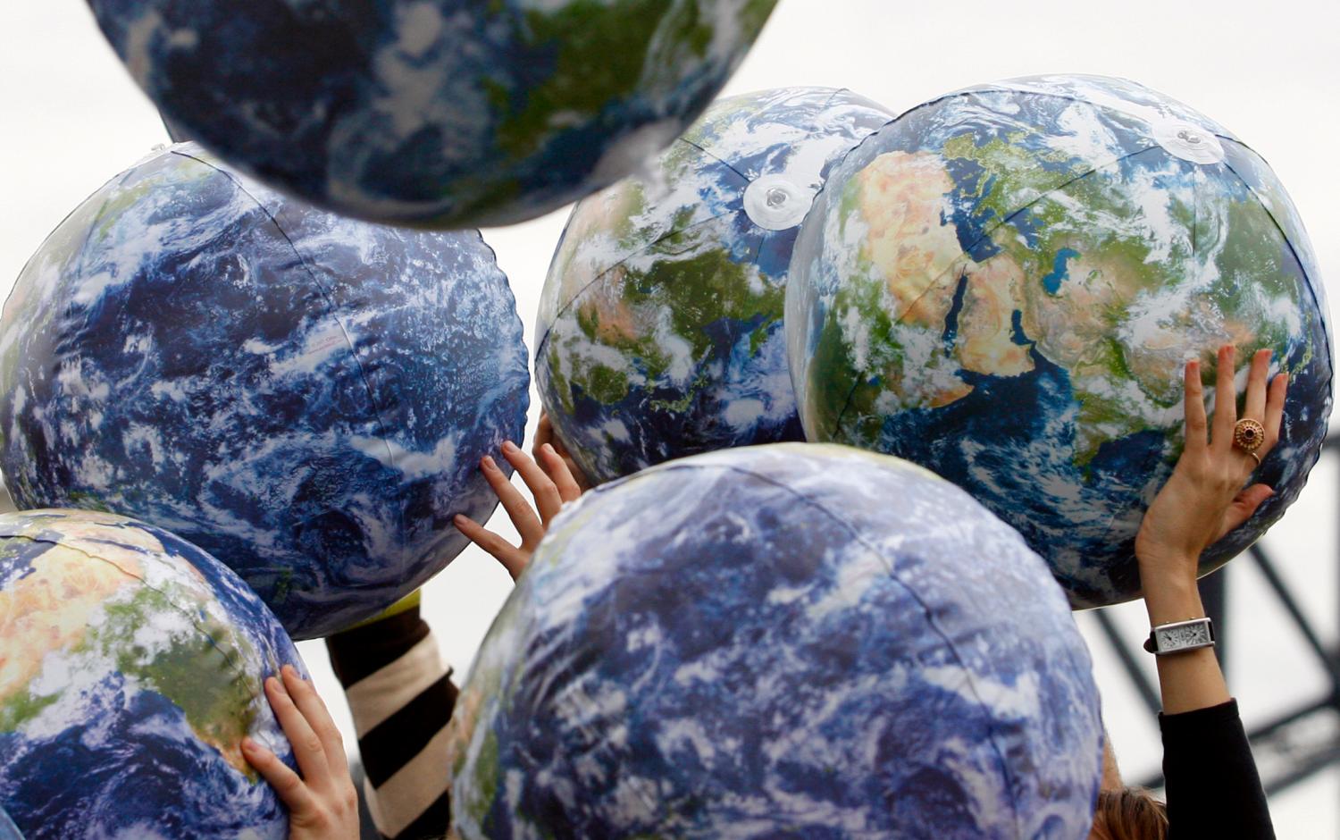 People hold up inflatable world globes during World Environment Day celebrations in central Sydney