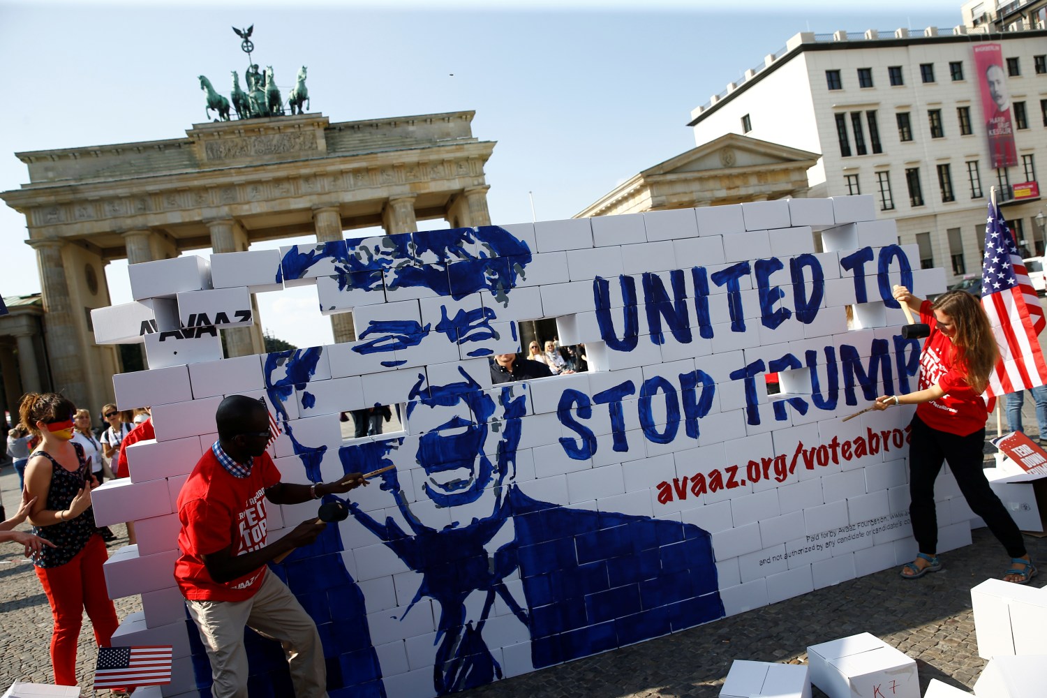 Campaigners pose on a 'United To Stop Trump' cardboard wall in front of the Brandenburg Gate to urge Americans living abroad to register and vote in Berlin, Germany, September 23, 2016. REUTERS/Axel Schmidt - RTSP3V6