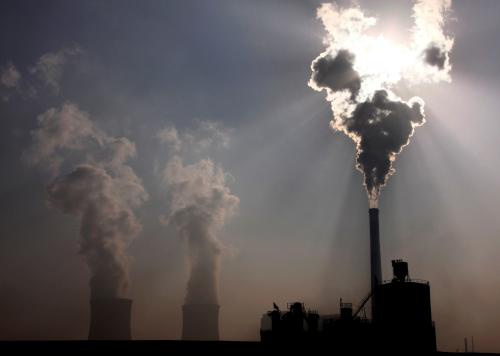 A coal-burning power plant can be seen behind a factory in the city of Baotou, in China's Inner Mongolia Autonomous Region October 31, 2010. REUTERS/David Gray/File Photo - RTSPKVR