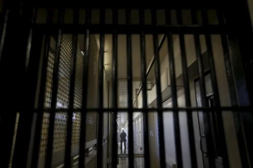 A guard stands behind bars at the Adjustment Center during a media tour of California's Death Row at San Quentin State Prison