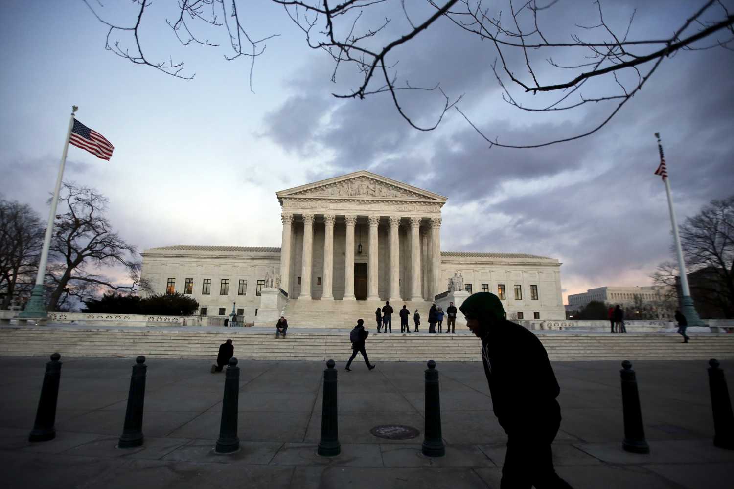 People stand outside the Supreme Court building at Capitol Hill