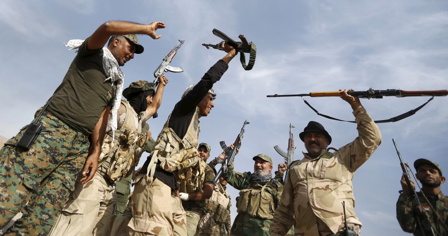 Shi'ite fighters chant slogans in al-Fatha, northeast of Baiji, October 18, 2015. Iraqi forces backed by Shi'ite militia fighters say they have retaken a mountain palace complex of former President Saddam Hussein from Islamic State fighters, as government forces push ahead on a major offensive against the insurgents. REUTERS/Thaier Al-Sudani - RTS4Z0Y