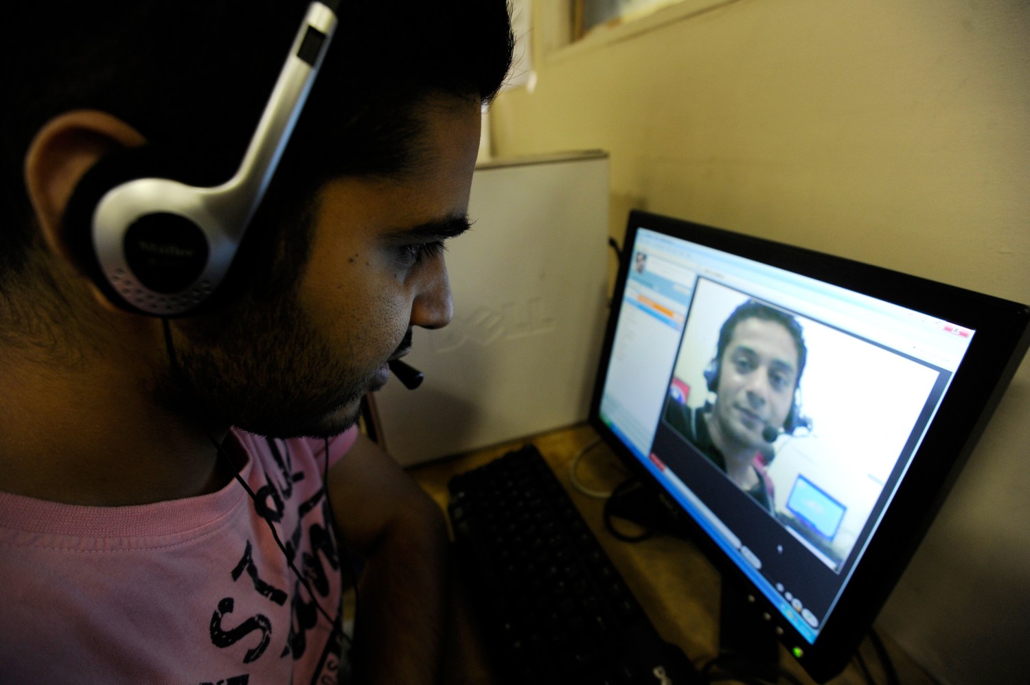 Zubair Ghumro (L) speaks to his friend Sheeraz Qazalbash using Skype