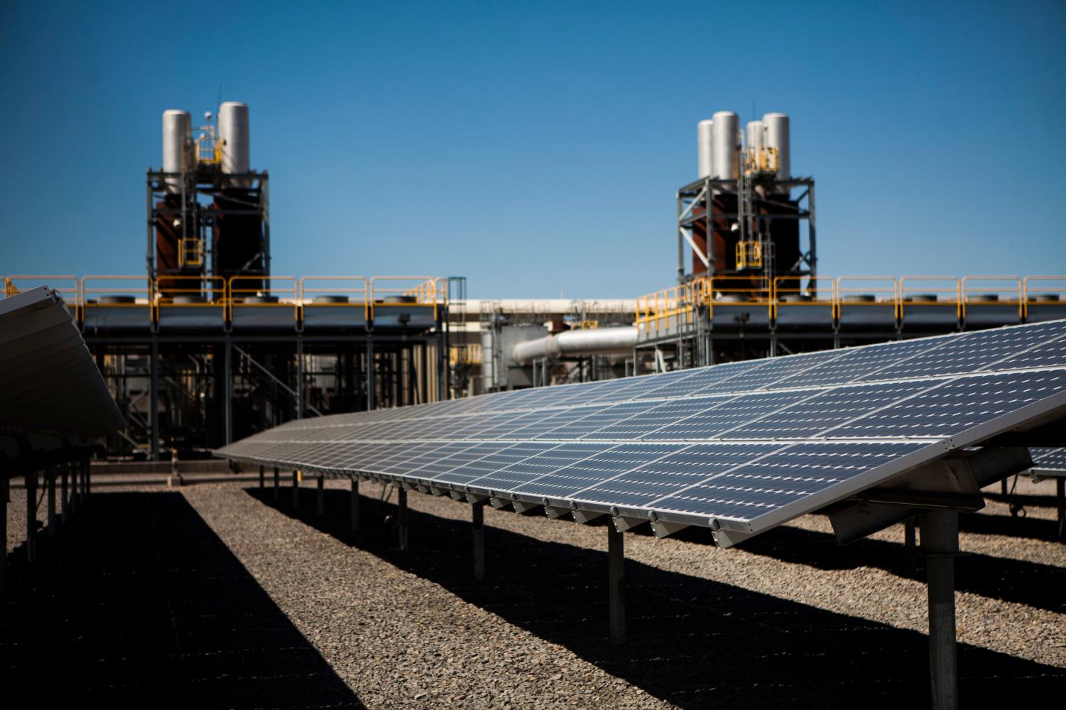 Solar panels are seen in front of a natural gas power plant at the Tahoe-Reno Industrial Center in McCarran, Nevada, September 16, 2014. This industrial site is where Elon Musk's electric car maker Tesla Motors plans to build a $5 billion factory to produce lithium ion batteries for electric cars, helped by more than $1 billion of incentives provided by Nevada. Tesla may employ 6,500 people at the new plant. In the past three years, 50 companies have moved to this area, helping cut unemployment in half and restoring some life to the town of Reno. Picture taken September 16. To match Feature USA-RENO/TESLA REUTERS/Max Whittaker (UNITED STATES - Tags: BUSINESS TRANSPORT ENERGY) - RTR48LGZ
