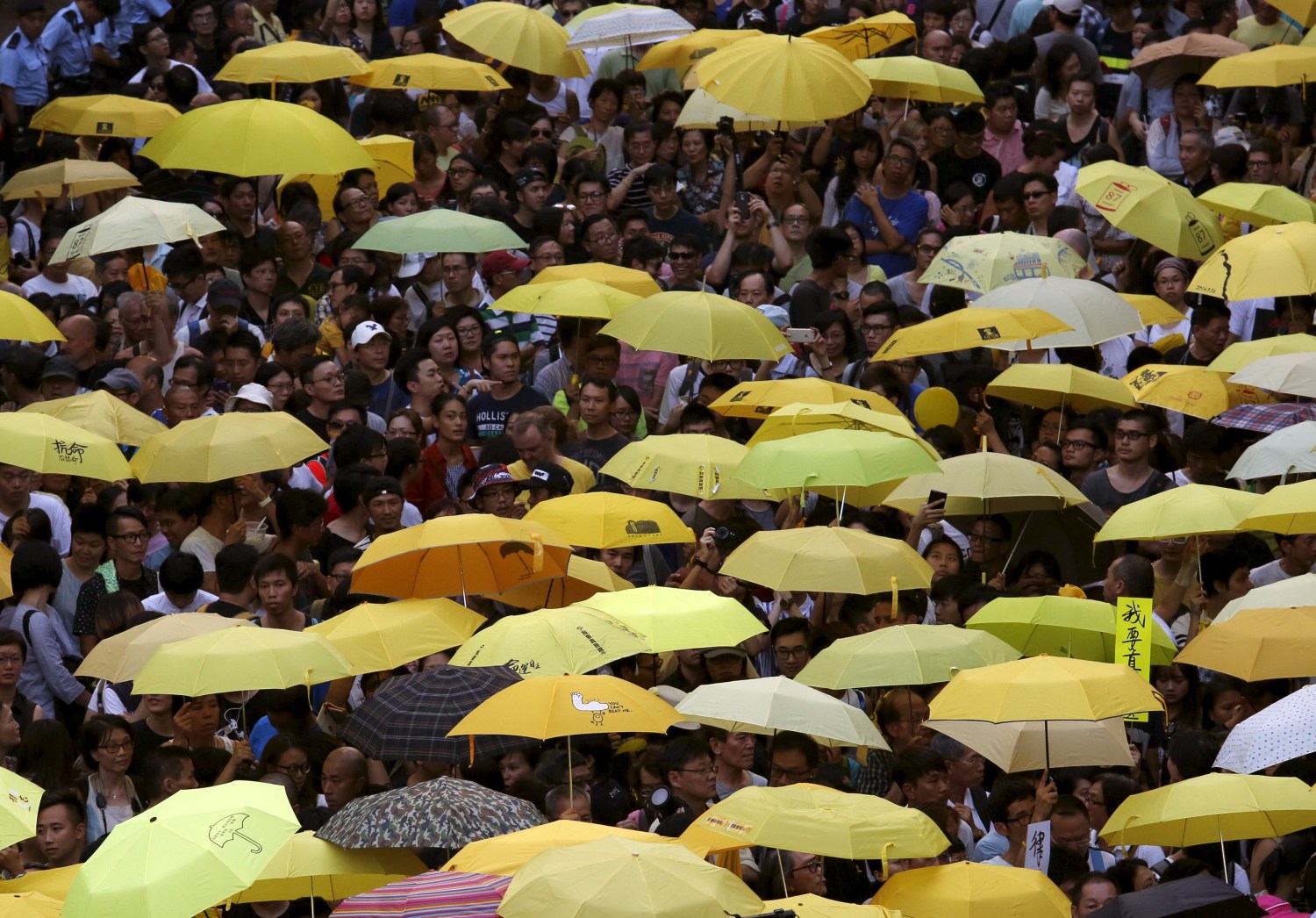 Pro-democracy protesters carrying yellow umbrellas, symbol of the Occupy Central civil disobedience movement, gather outside government headquarters in Hong Kong, China September 28, 2015. Monday marks the first anniversary of the Occupy Central or "umbrella" movement, demanding universal suffrage in the territory. REUTERS/Bobby Yip - RTX1SU40