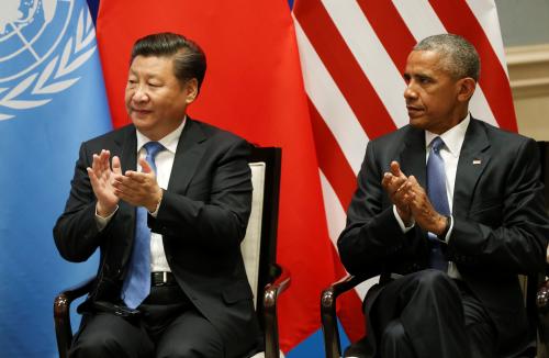 U.S. President Barack Obama and Chinese President Xi Jinping clap as UN Secretary General Ban Ki-moon (not pictured) delivers his speech