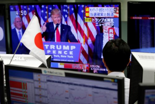 An employee of a foreign exchange trading company looks at a monitor showing U.S. President-elect Donald Trump speaking on TV news in Tokyo, Japan, November 9, 2016. REUTERS/Toru Hanai - RTX2SQFJ