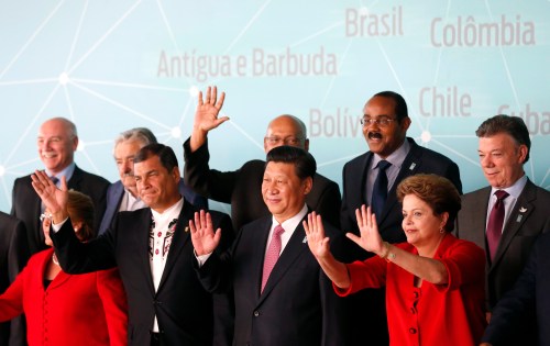Brazil's President Dilma Roussff (2nd R) waves with Colombia's President Juan Manuel Santos (R), Prime Minister of Antigua and Barbuda, Gaston Browne (3rd R), President of the Republic of Guyana Donald Rabindranauth Ramotar (C left), China's President Xi Jinping (C), Ecuador's President Rafael Correa (4th L), Uruguay's President Jose Mujica (3rd L), Chile's President Michelle Bachelet (2nd L) and Paraguay's Foreign Minister Eladio Loizaga as they pose for the official photo session for the meeting of China and CELAC at Itamaraty Palace in Brasilia July 17, 2014. Brazil hosted the meeting of China and Community of Latin American and Caribbean States (CELAC). REUTERS/Sergio Moraes (BRAZIL - Tags: POLITICS) - RTR3Z4DQ