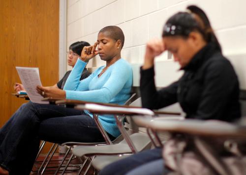 Students listen to their professor at a community college.
