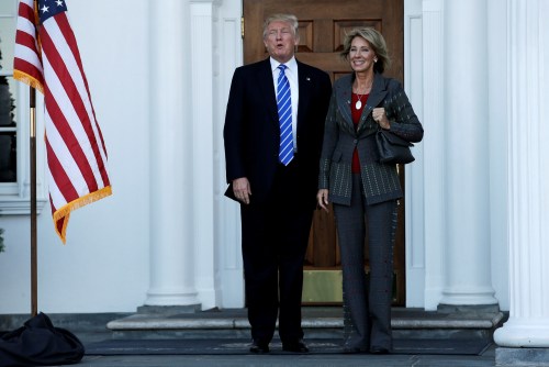 U.S. President-elect Donald Trump (L) stands with Betsy DeVos after their meeting at the main clubhouse at Trump National Golf Club in Bedminster, New Jersey