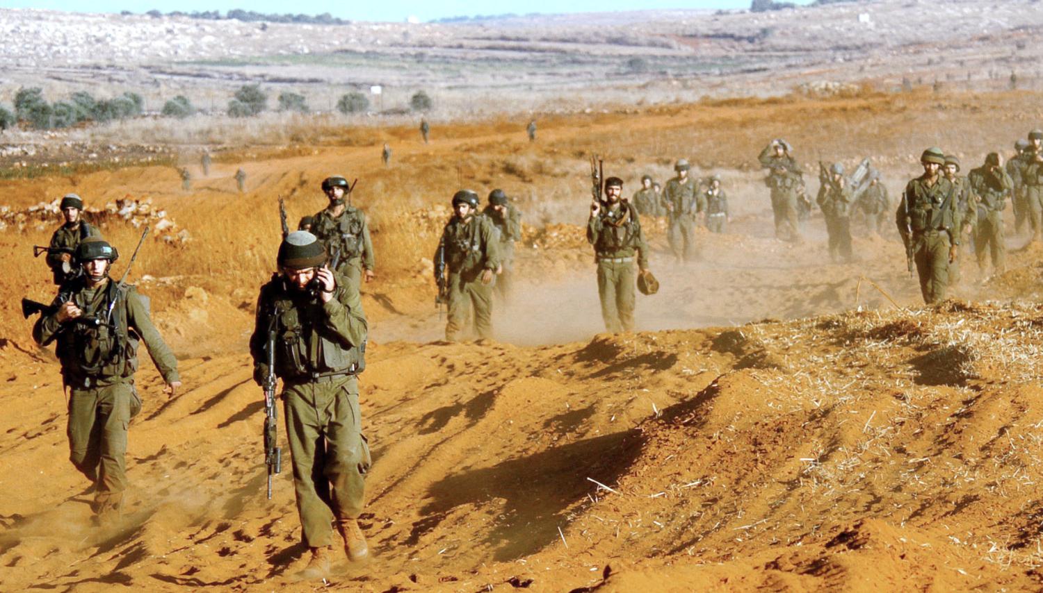 Israeli soldiers walk together after leaving Lebanon, near the Israeli-Lebanon border August 14, 2006 in this picture released by the Israeli Defense Forces. Guns fell silent across southern Lebanon on Monday after a U.N.-brokered truce went into effect to end five weeks of fighting between Israel and Hizbollah that killed more than 1,250 people and wounded thousands. REUTERS/Dan Bronfeld/IDF/Handout (ISRAEL) - RTR1GDDI