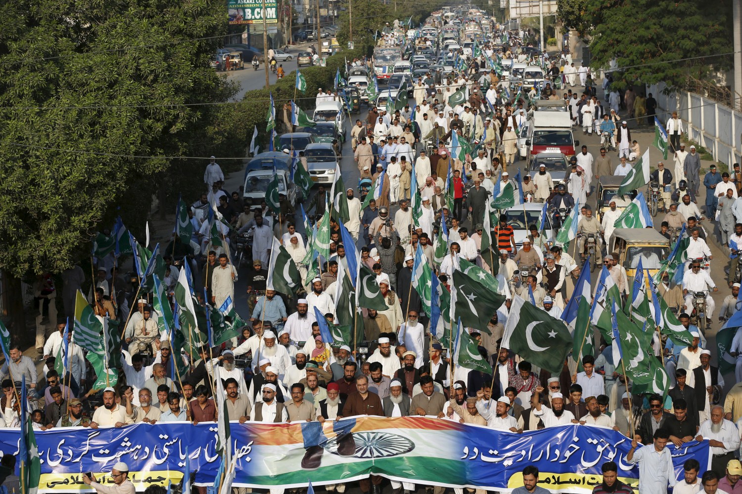 Supporters of the Jamaat-e-Islami political party hold flags as they march during a rally to mark Kashmir Solidarity Day, in Karachi, Pakistan February 5, 2016. REUTERS/Akhtar Soomro - RTX25LYM