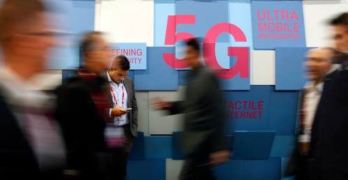 People walk past a 5G banner during the Mobile World Congress in Barcelona, Spain