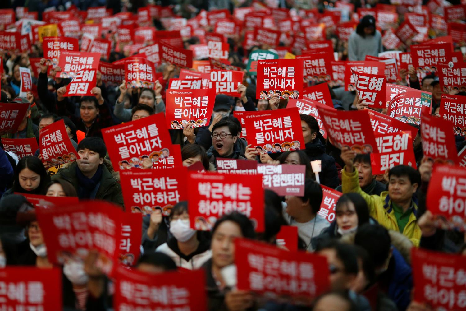 People chant slogans during a protest calling South Korean President Park Geun-hye to step down in Seoul, South Korea, November 19, 2016. The sign reads "Step down Park Geun-hye". REUTERS/Kim Hong-Ji - RTSSCDE