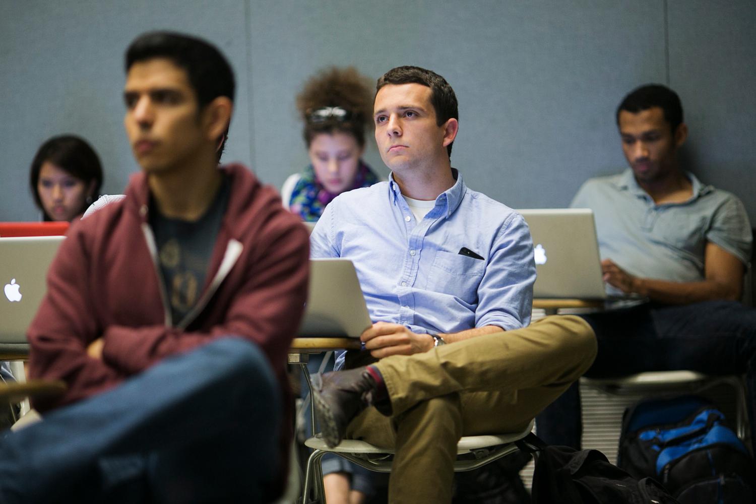 Students listen to a presentation while in class at Stanford University.,