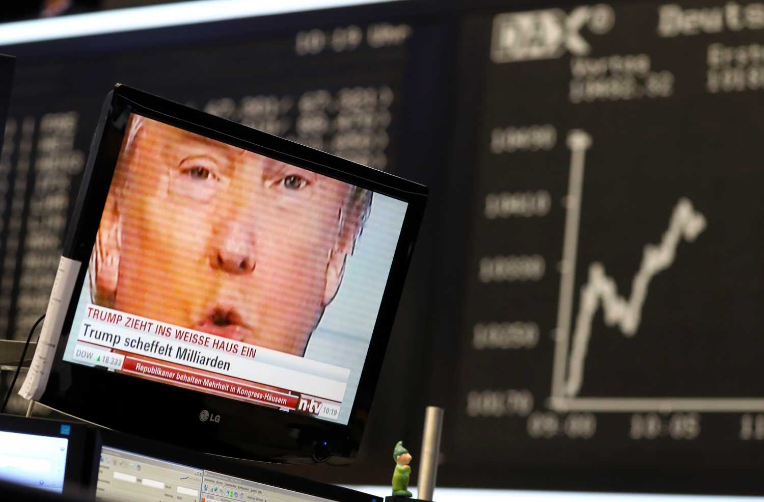 A TV screen showing U.S. President-elect Donald Trump is pictured in front of the German share price index, DAX board, at the stock exchange in Frankfurt, Germany, November 9, 2016. REUTERS/Kai Pfaffenbach - RTX2SQVH