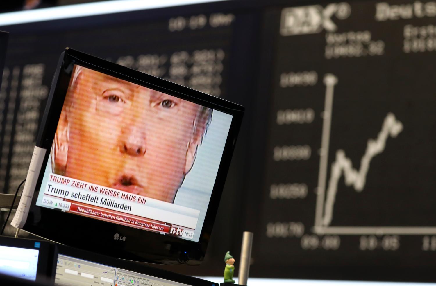 A TV screen showing U.S. President-elect Donald Trump is pictured in front of the German share price index, DAX board, at the stock exchange in Frankfurt, Germany, November 9, 2016. REUTERS/Kai Pfaffenbach - RTX2SQVH