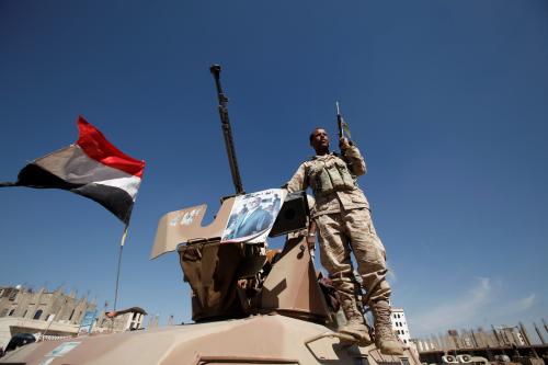 A pro-Houthi soldier stands on a military armoured personnel carrier next to a poster of Yemen's former President Ali Abdullah Saleh during a tribal gathering held to mobilize fighters for battles against government forces, in Sanaa, Yemen November 24, 2016. REUTERS/Khaled Abdullah - RTST35J