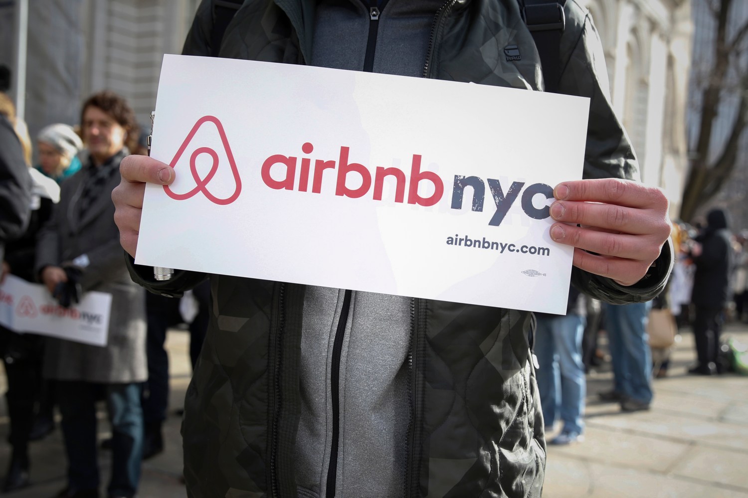 Supporter holds an Airbnb sign
