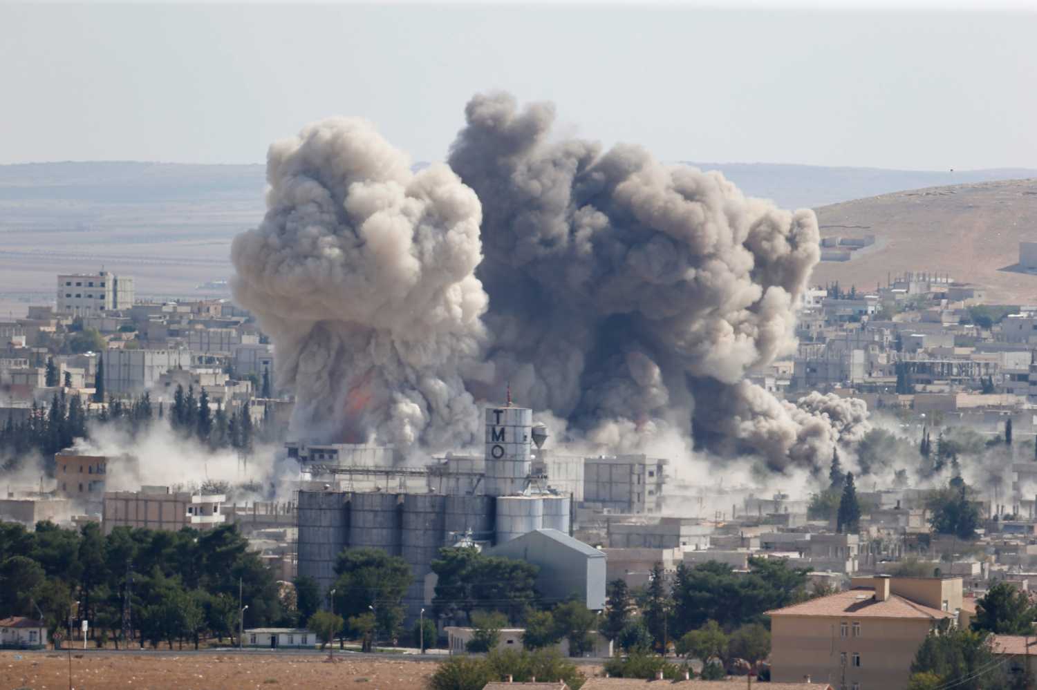 Smoke rises after an U.S.-led air strike in the Syrian town of Kobani Ocotber 8, 2014. U.S.-led air strikes on Wednesday pushed Islamic State fighters back to the edges of the Syrian Kurdish border town of Kobani, which they had appeared set to seize after a three-week assault, local officials said. The town has become the focus of international attention since the Islamists' advance drove 180,000 of the area's mostly Kurdish inhabitants to flee into adjoining Turkey, which has infuriated its own restive Kurdish minority-- and its NATO partners in Washington -- by refusing to intervene. REUTERS/Umit Bektas (SYRIA - Tags: POLITICS CONFLICT TPX IMAGES OF THE DAY) - RTR49CYL