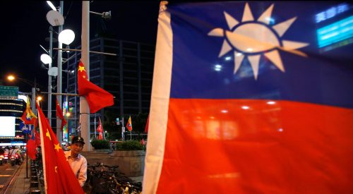 A pro-China supporter adjusts a China national flag during a rally calling for peaceful reunification, days before the inauguration ceremony of President-elect Tsai Ing-wen, in Taipei, Taiwan May 14, 2016. REUTERS/Tyrone Siu TPX IMAGES OF THE DAY - RTSEBXZ