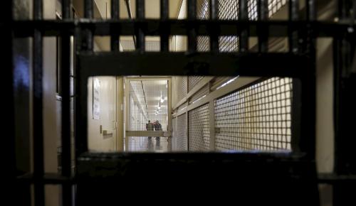 A shot of a state prison is shown from behind a cell door.